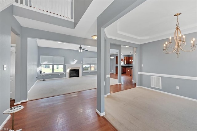 interior space featuring ceiling fan with notable chandelier and hardwood / wood-style flooring