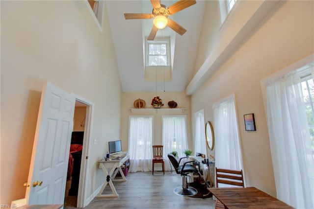 entryway featuring wood-type flooring, ceiling fan, plenty of natural light, and a towering ceiling