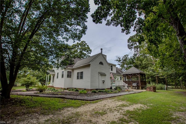 view of property exterior featuring a sunroom and a lawn