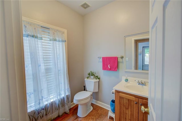 bathroom with vanity, toilet, and hardwood / wood-style flooring