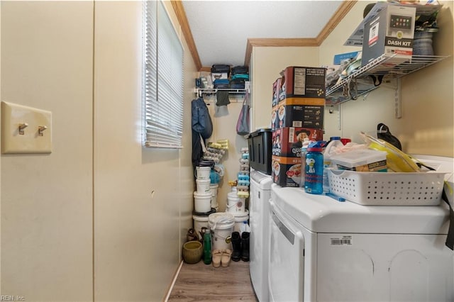 laundry room featuring laundry area, washer and dryer, ornamental molding, and wood finished floors