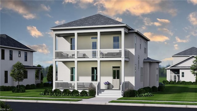 view of front of house with a balcony and a lawn