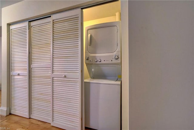 clothes washing area with stacked washer and dryer and light hardwood / wood-style floors