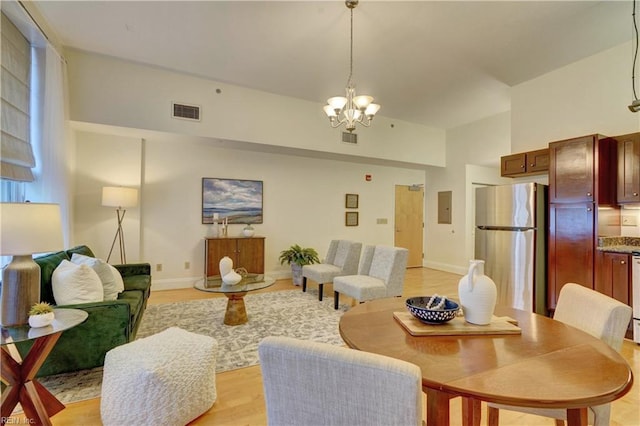 living room featuring light wood-type flooring, electric panel, and an inviting chandelier