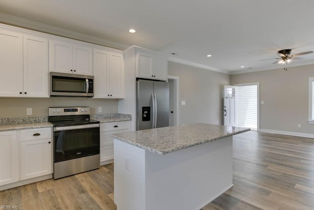 kitchen featuring light wood-type flooring, appliances with stainless steel finishes, and white cabinetry