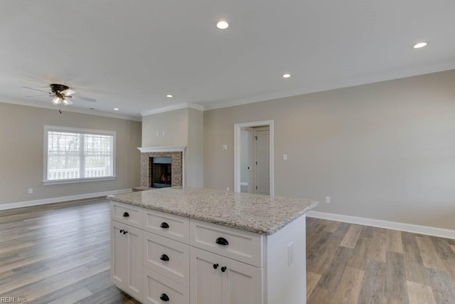 kitchen featuring ceiling fan, light stone countertops, light wood-type flooring, and white cabinets