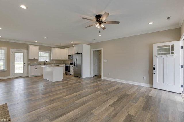 kitchen featuring stainless steel appliances, white cabinets, and light hardwood / wood-style floors