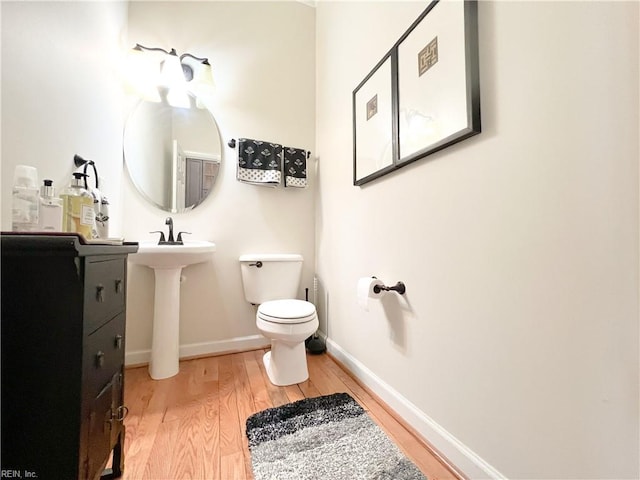 bathroom with wood-type flooring and toilet