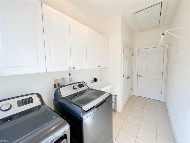 washroom featuring light tile patterned floors, cabinets, washing machine and dryer, and sink