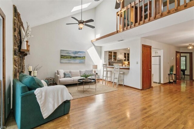 living room with ceiling fan, high vaulted ceiling, and hardwood / wood-style flooring