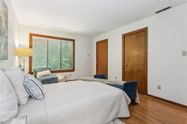 bedroom with wood-type flooring and electric panel