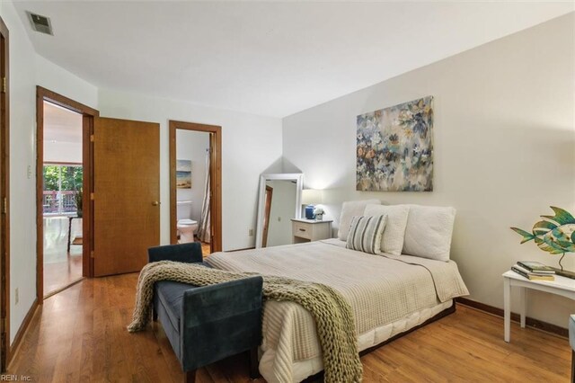 bedroom featuring light hardwood / wood-style floors and ensuite bathroom