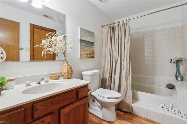 full bathroom featuring vanity, toilet, wood-type flooring, and shower / bathtub combination with curtain