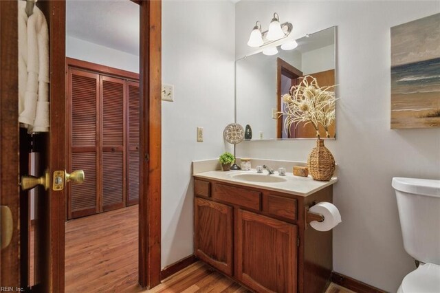 bathroom with hardwood / wood-style floors, toilet, and vanity