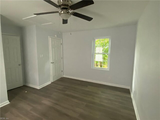 empty room with dark hardwood / wood-style floors and ceiling fan