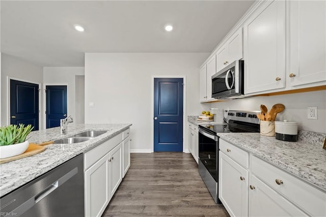 kitchen featuring dark wood-type flooring, white cabinets, sink, appliances with stainless steel finishes, and light stone counters