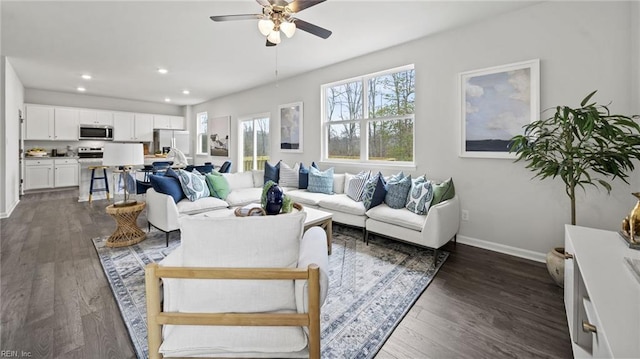 living room featuring ceiling fan and dark hardwood / wood-style flooring