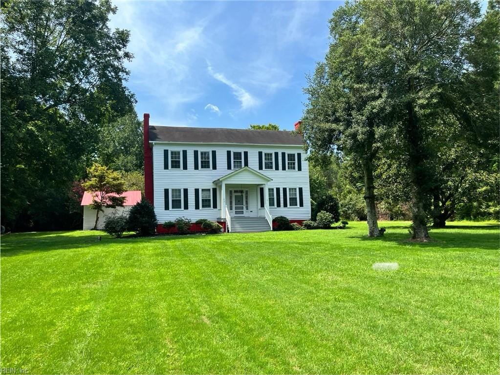 colonial home featuring a front lawn