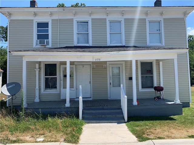 italianate house with a porch, cooling unit, and a chimney
