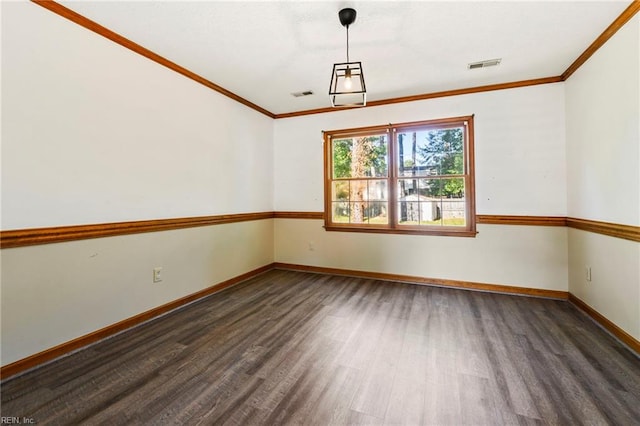 spare room featuring ornamental molding, visible vents, and wood finished floors
