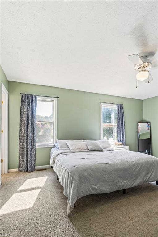 carpeted bedroom with baseboards and ceiling fan