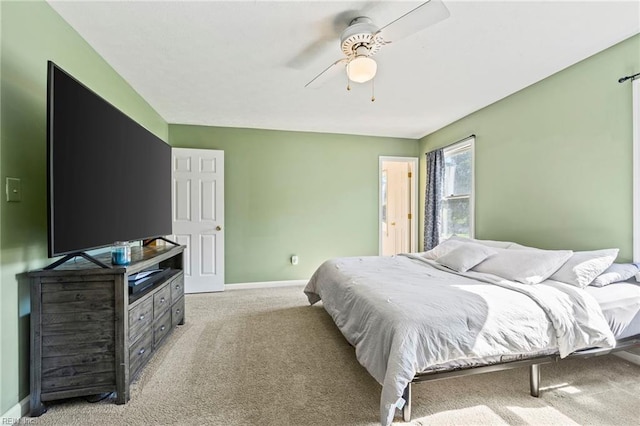 bedroom featuring baseboards, light colored carpet, and ceiling fan