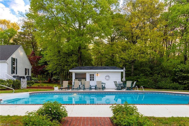 view of pool with an outbuilding and a patio area