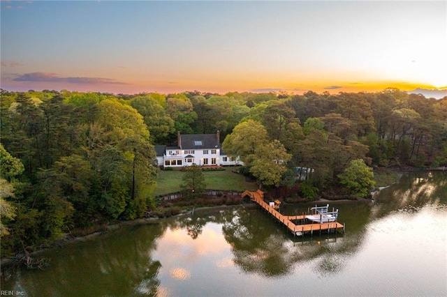 aerial view at dusk featuring a water view