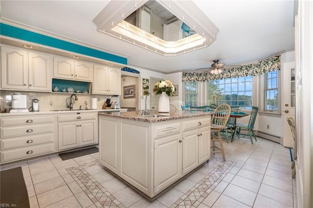 8429 Denwood Rd, Franktown, VA 23354 - kitchen with a sink, light tile patterned flooring, a kitchen island, backsplash, and crown molding