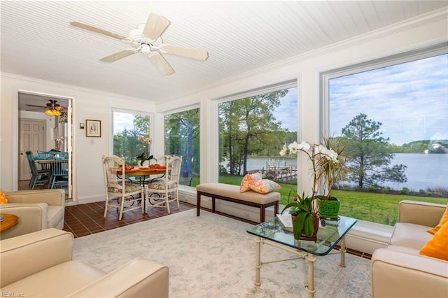 sunroom / solarium featuring a water view and ceiling fan