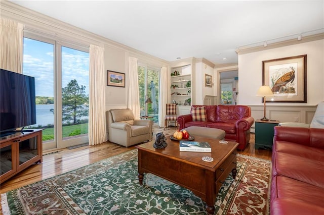 living room with built in features, crown molding, baseboard heating, and hardwood / wood-style floors