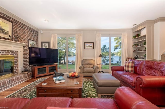 living room with wood-type flooring, a fireplace, and crown molding