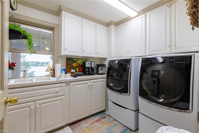 washroom with ornamental molding, washing machine and clothes dryer, cabinets, and sink