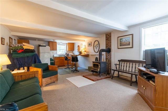 living room with light colored carpet, a wood stove, and beamed ceiling