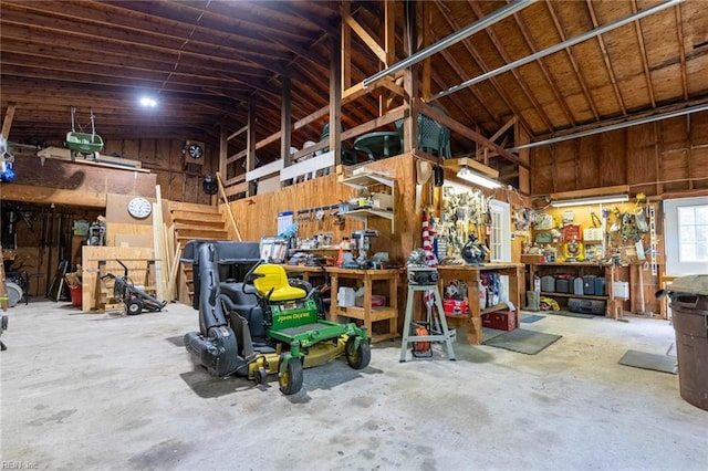 garage with wooden walls and a workshop area