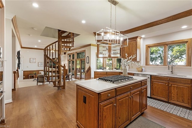 kitchen featuring a kitchen island, appliances with stainless steel finishes, light hardwood / wood-style flooring, sink, and decorative light fixtures