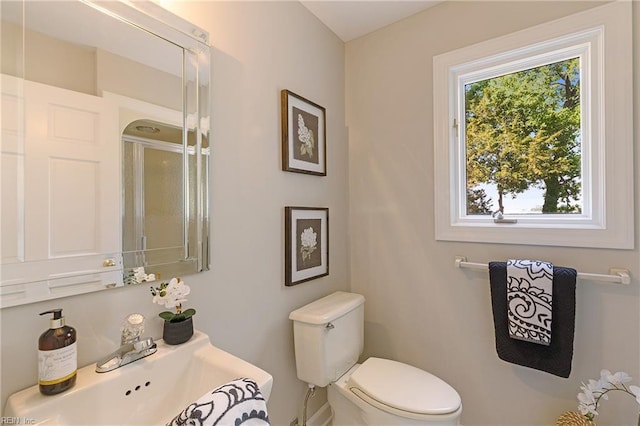 bathroom with sink, toilet, and an enclosed shower