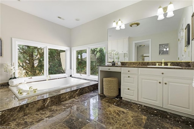 bathroom with vanity and tiled bath