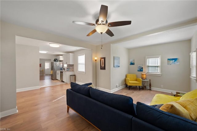 living room with ceiling fan, a wealth of natural light, and light hardwood / wood-style floors