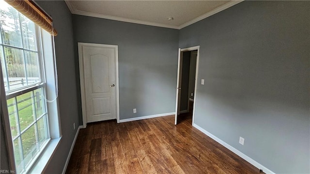 unfurnished room with a wealth of natural light, dark hardwood / wood-style flooring, and ornamental molding