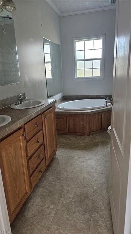 bathroom featuring a bathtub, vanity, a textured ceiling, and ornamental molding