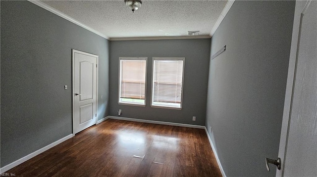 empty room with a textured ceiling, dark hardwood / wood-style floors, and crown molding