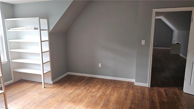 additional living space with hardwood / wood-style flooring and lofted ceiling