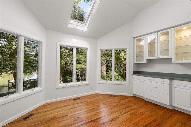 interior space with a healthy amount of sunlight and lofted ceiling with skylight