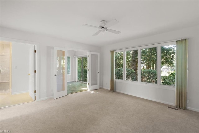 carpeted empty room featuring ceiling fan and french doors