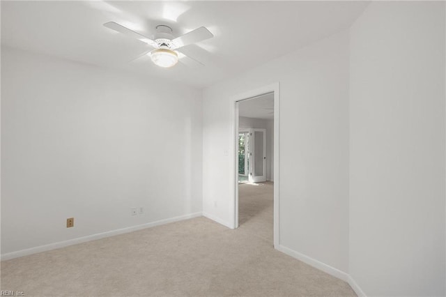 spare room featuring light colored carpet and ceiling fan