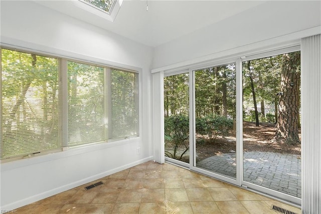 unfurnished sunroom featuring a skylight