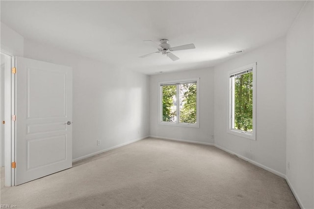 carpeted spare room featuring ceiling fan