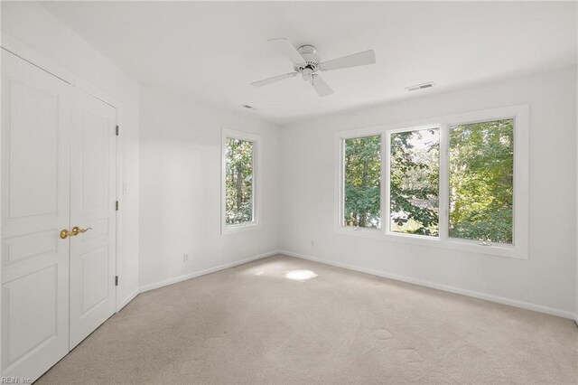 carpeted spare room with ceiling fan