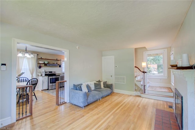 living room featuring light wood-type flooring and a chandelier